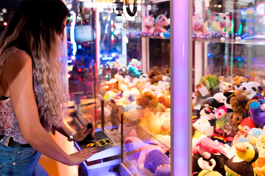 eine Dame, die Claw Machine spielt