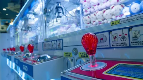 Row Of Colorful Arcade Claw Machines With Prizes