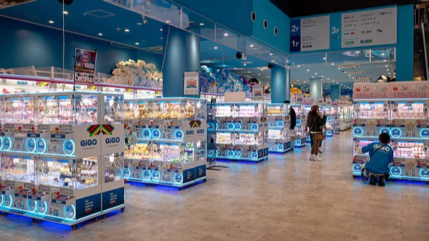 Rows of illuminated UFO claw machines filled with prizes at an arcade shop